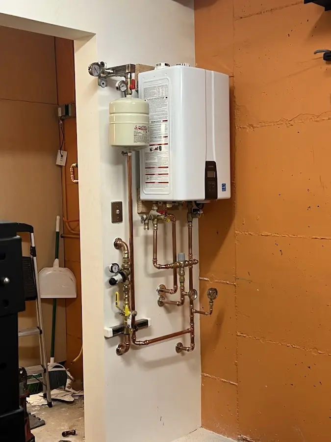 Plumbing technician inspecting water heater connections in Highland Lakes